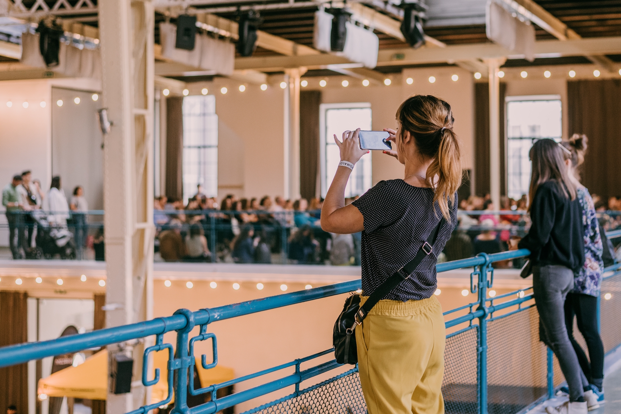 woman using mobile phone to take photos of an event going on, photo for event management services